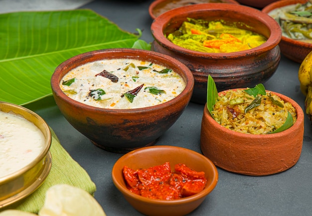 Platos tradicionales de fiesta de Kerala dispuestos en fondo de color gris