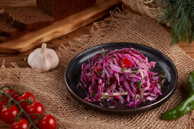 Platos ucranianos y rusos - repollo agrio marinado casero con zanahorias en un plato sobre la madera