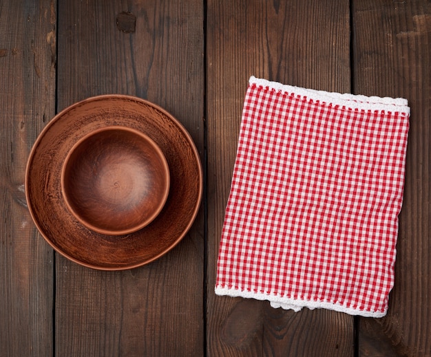 Platos vacíos de cerámica marrón y toalla de cocina a cuadros