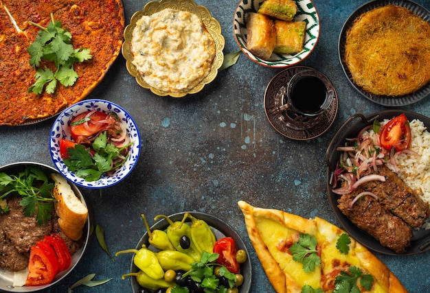 Platos variados de comida turca tradicional y aperitivos de mezze sobre un fondo rústico desde arriba Pide Lahmacun kebab de carne Albóndigas turcas baklava dulce y espacio de copia de la cocina de Medio Oriente de Kunefe