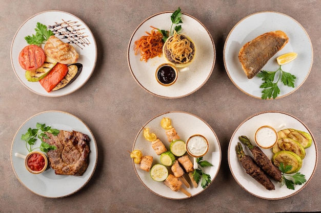 Foto platos variados: pavo con verduras a la plancha, bife con puré de patatas, bacalao frito, bife de cerdo con salsa, salmón con verduras a la plancha, rollitos de ternera con espárragos.