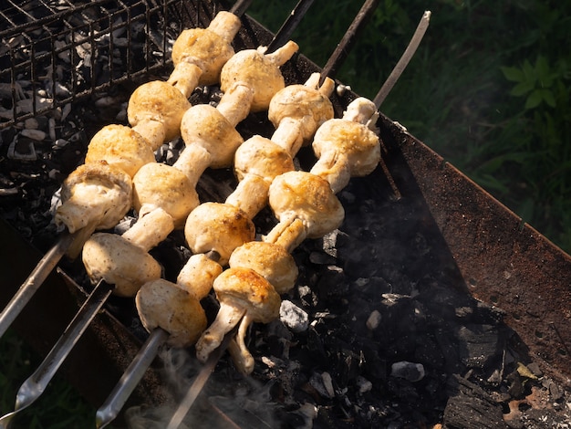 Platos vegetarianos de deliciosos champiñones, champiñones cocinados sobre carbón a la parrilla.