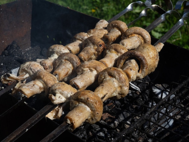 Platos vegetarianos de deliciosos champiñones, champiñones cocinados sobre carbón a la parrilla.