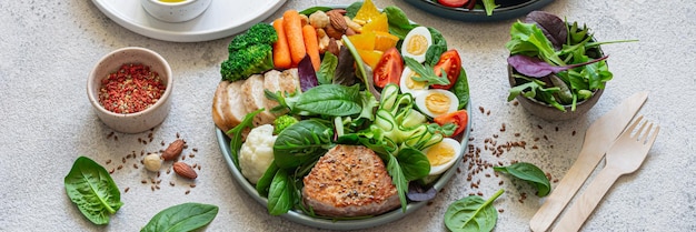 Foto platos de verduras con carne, pescado y huevos dieta completa para el día