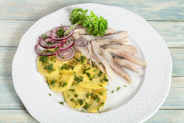 Platte des Heringsfisches mit Kartoffelscheiben und roter Zwiebel