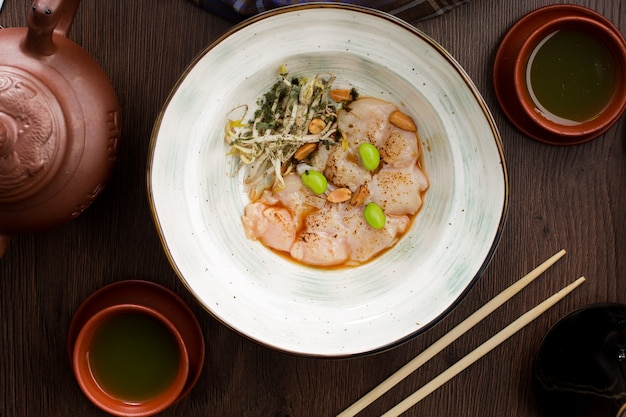 Platte mit Jakobsmuscheln und Nüssen in einem asiatischen Restaurant