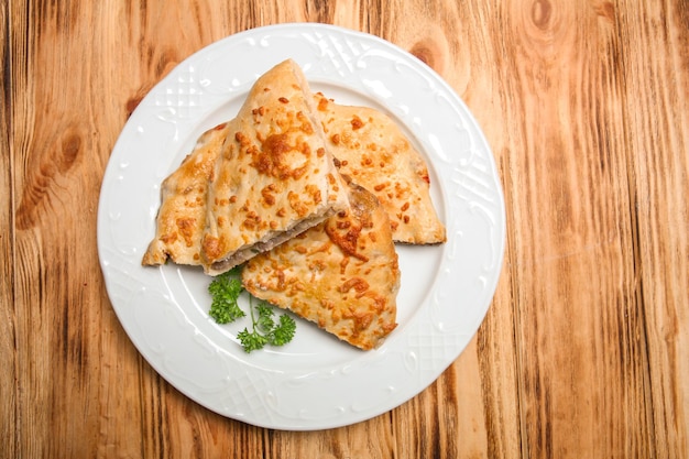 Platte mit lecker gefüllten Khachapuri auf Holztisch