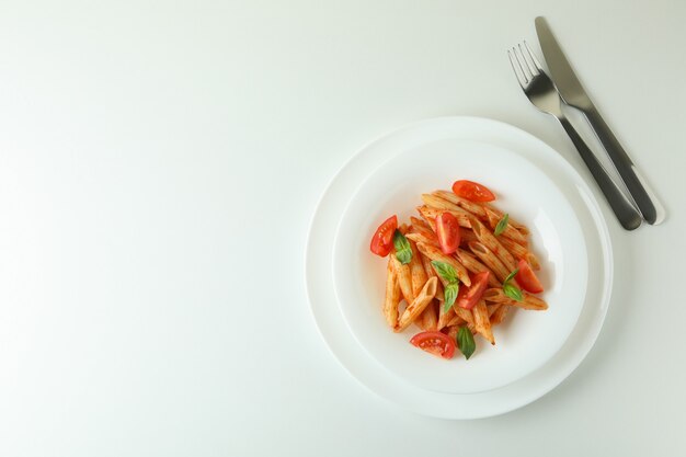 Platte mit Nudeln mit Tomatensauce auf weißem isoliertem Hintergrund