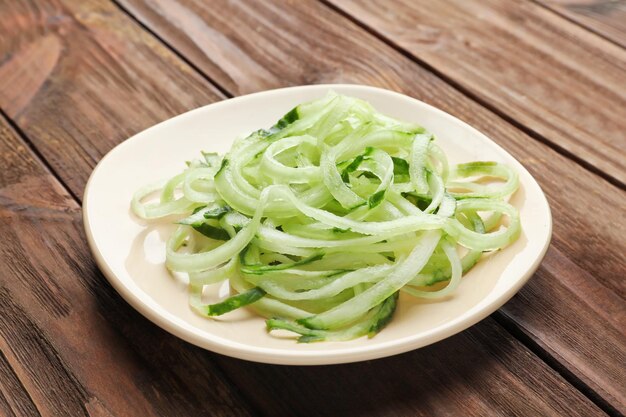 Platte mit rohen Gemüsespaghetti auf Holztisch