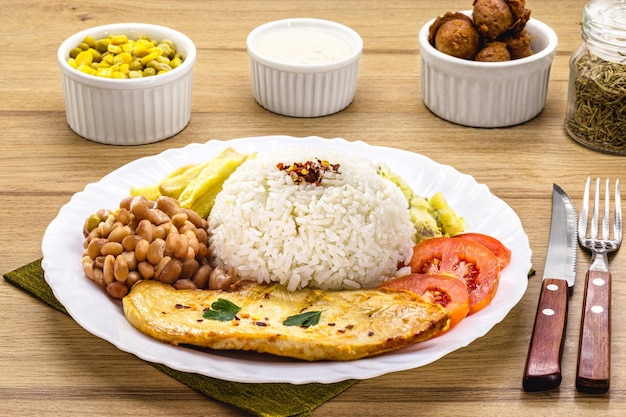 Platte mit typisch brasilianischem Gericht gebratenem Hühnerfiletreis mit Bohnen und Salat Farofa Brasilianisches Executive-Mittagessen, das in Restaurants serviert wird