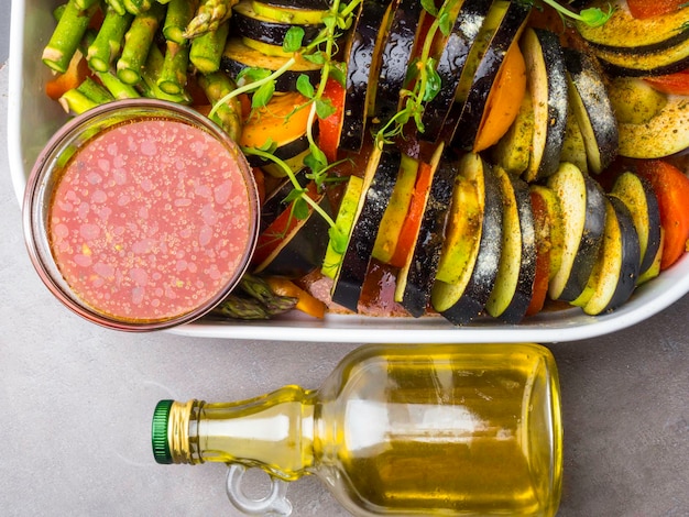 Platte mit verschiedenem frischem Gemüse mit roter Tomatensoße und Öl