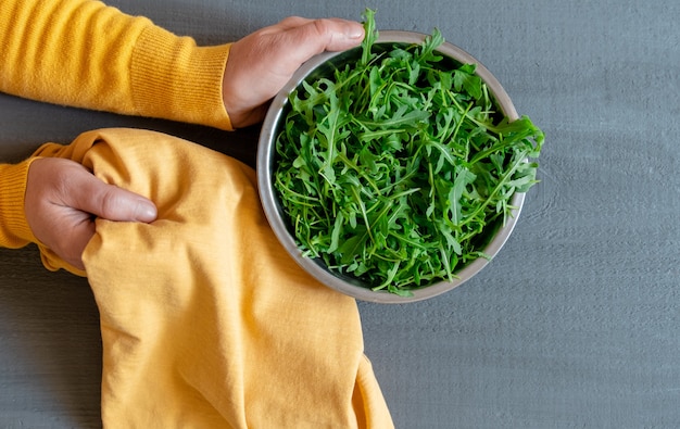 Platte Rucola grüne Hand gelb grau Hintergrund Kopie Raum Fortuna Gold Farbe