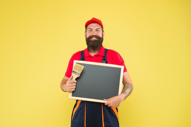 Platz kopieren Professionelle Werkstatt wollte Baumeister Mann malen auf Tafel bärtiger Arbeiter Malpinsel brutaler Baumeister Mann eigene Geschäftsankündigung und Werbung starten