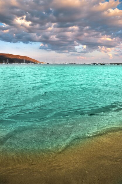 Una playa con agua azul y un cielo nublado