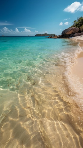 Una playa de agua azul y una playa de arena blanca con una isla rocosa al fondo.