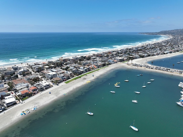 Foto una playa con algunos barcos y una playa y un cuerpo de agua con una playa y casas en el fondo