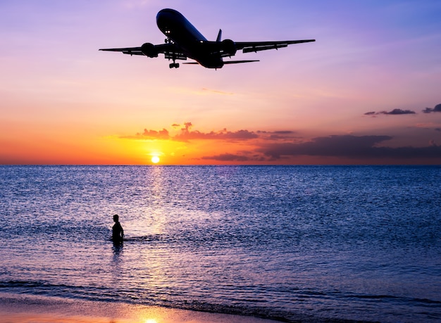 Playa de arena con aeroplano y cielo puesta de sol en crepúsculo concepto de viaje