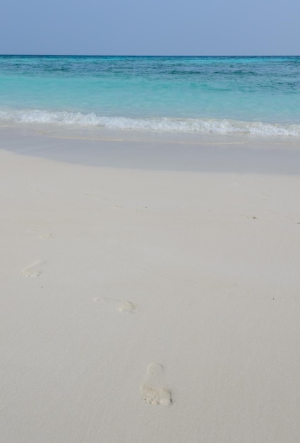 Playa de arena blanca y agua cristalina con huella