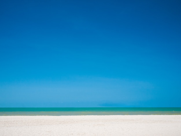 Foto playa de arena blanca con cielo azul sobre el mar