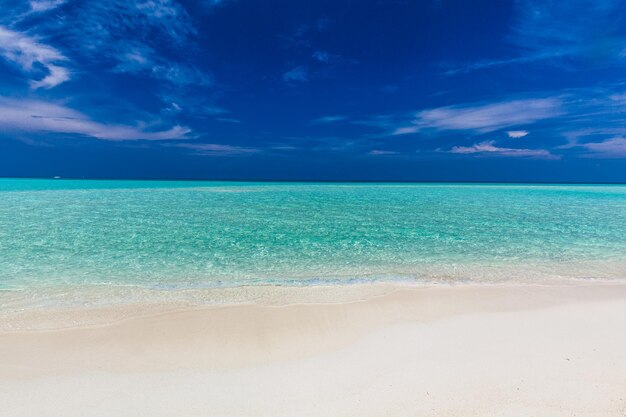 Playa de arena blanca en Maldivas con una increíble laguna azul y un cielo azul