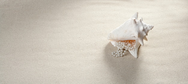 Foto playa arena collar de perlas concha vacaciones de verano