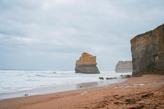 Foto playa de arena con grandes olas en el great ocean road de los doce apóstoles australia