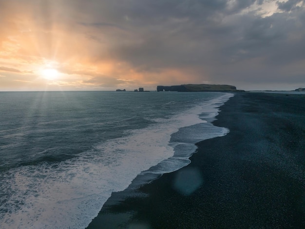 Playa de arena negra de Islandia con enormes olas en reynisfjara vik