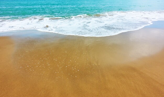 Playa de arena y oleaje suave - - fondo con gran espacio para su propio texto