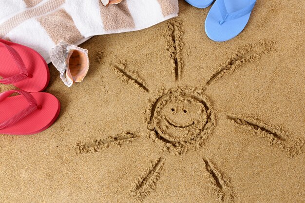 Playa de arena con sol sonriente