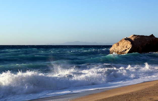 Playa arenosa del mar tempestuoso de las olas grandes en la isla de Grecce de Lefkada