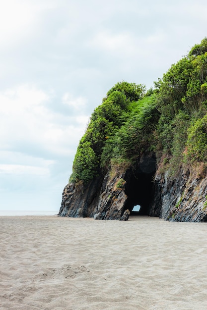 Foto playa de asturias con un acantilado y una cueva