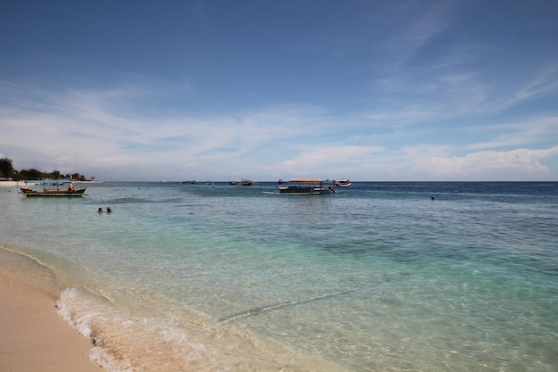 Una playa con un barco en la distancia.