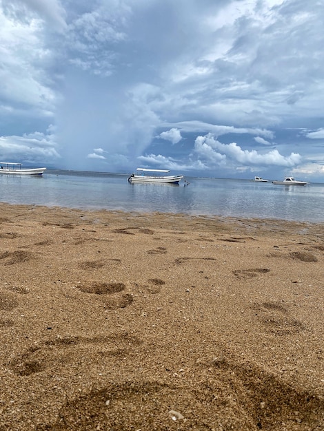 Una playa con barcos y un cielo nublado