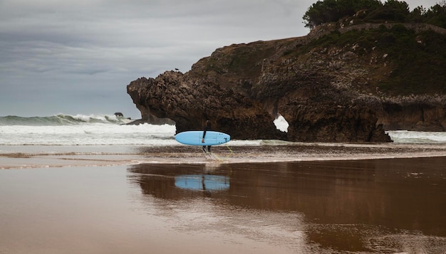 Playa Cantábrica con marea creciente en un día nublado de verano