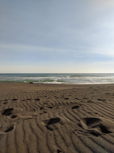 Una playa con un cielo azul y el mar de fondo