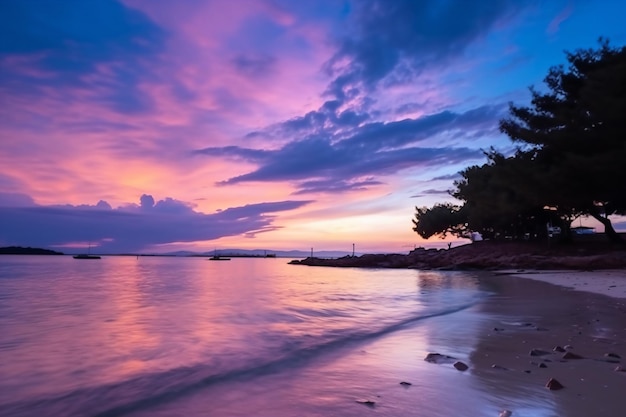 Una playa con un cielo morado y el sol reflejado en el agua.