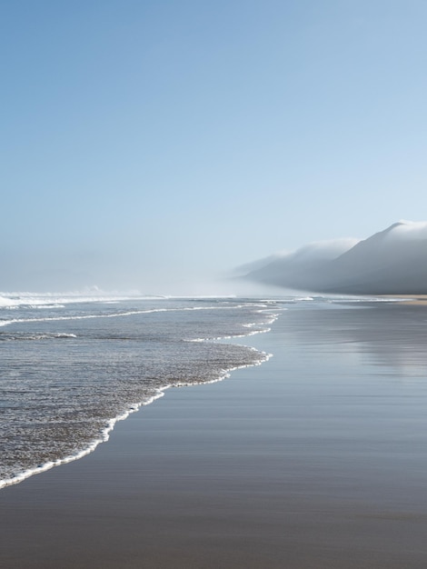 Playa de Cofete en Fuerteventura Playa virgen bajo el paisaje neblinoso de las montañas