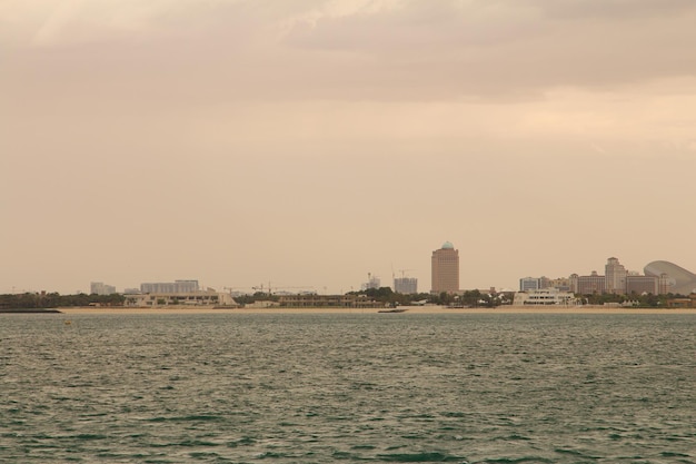 Foto una playa con un edificio en el fondo y una ciudad en el fondo