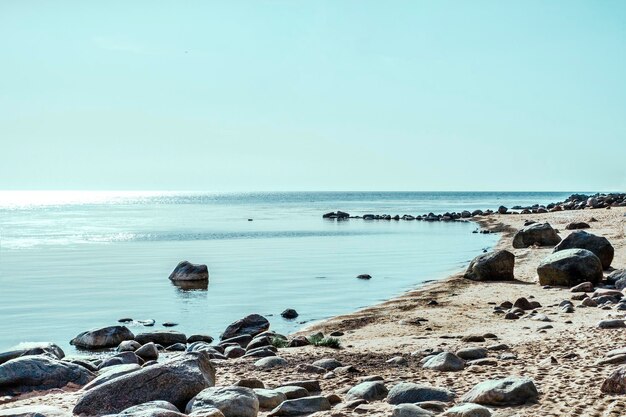 Foto una playa con un faro en el horizonte