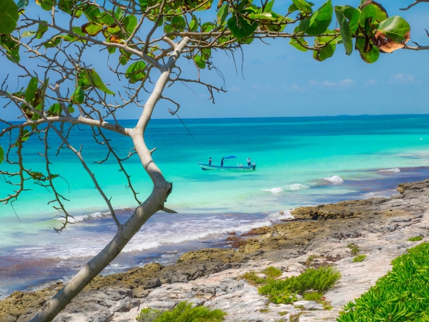 Playa hermosa y soleada con agua azul limpia y chicos en el barco