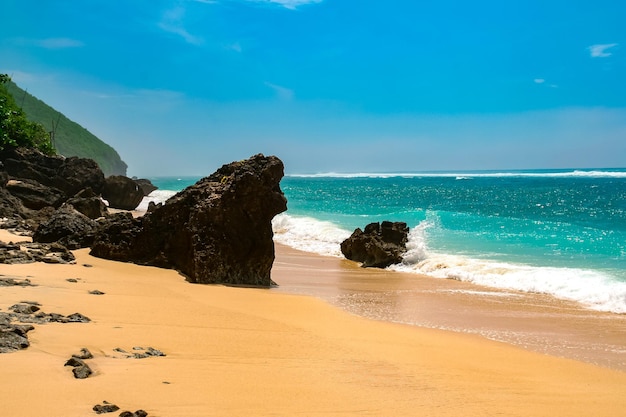 Foto playa en la isla tropical agua azul clara arena y piedras