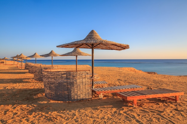 Playa junto al mar con sombrillas y un muelle para nadar Mar Rojo Egipto