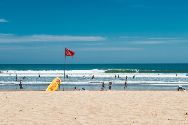 Playa de kuta, bali, indonesia. Punto de rescate de surf. Tabla de surf de rescate amarilla y bandera roja.