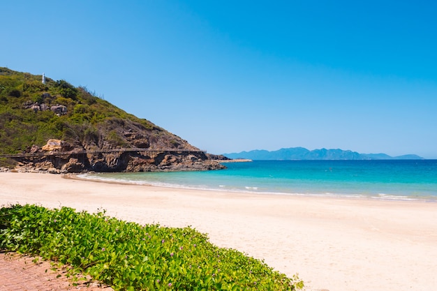 Playa con mar cerca de la isla rocosa