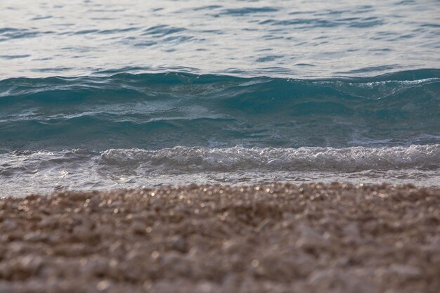 Playa de mar cerca de olas pequeñas puesta de sol