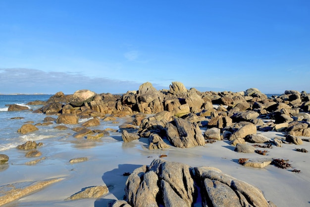 Playa en el mar de iroise con rocas en el mar bajo un cielo azul en Bretaña - Francia