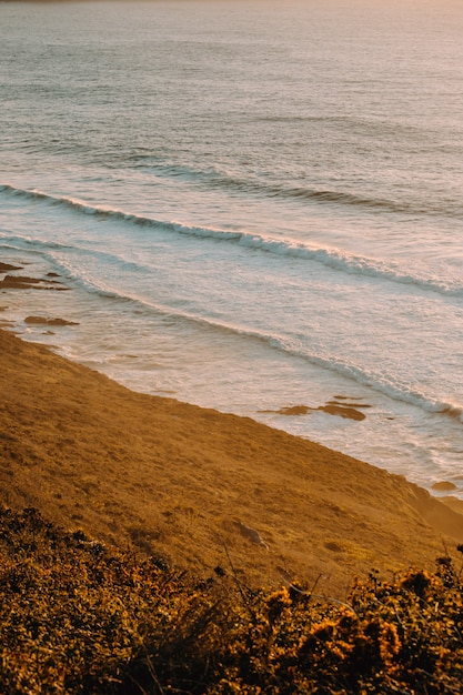 Playa masiva con olas durante una puesta de sol súper soleada en tonos vintage