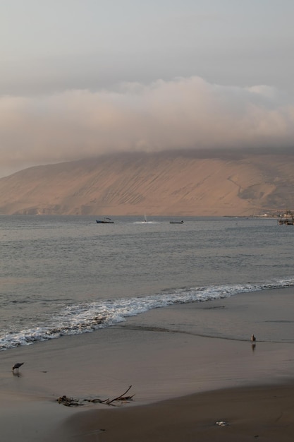 Una playa con una montaña al fondo.