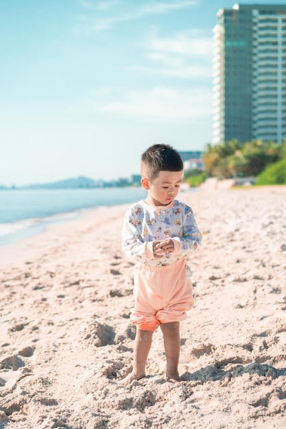 En la playa, un niño juega en la arena.