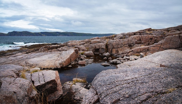 La playa en el océano norte está hecha de piedras cubiertas de musgo de colores. Teriberka, Mar de Barents, región de Murmansk, Península de Kola